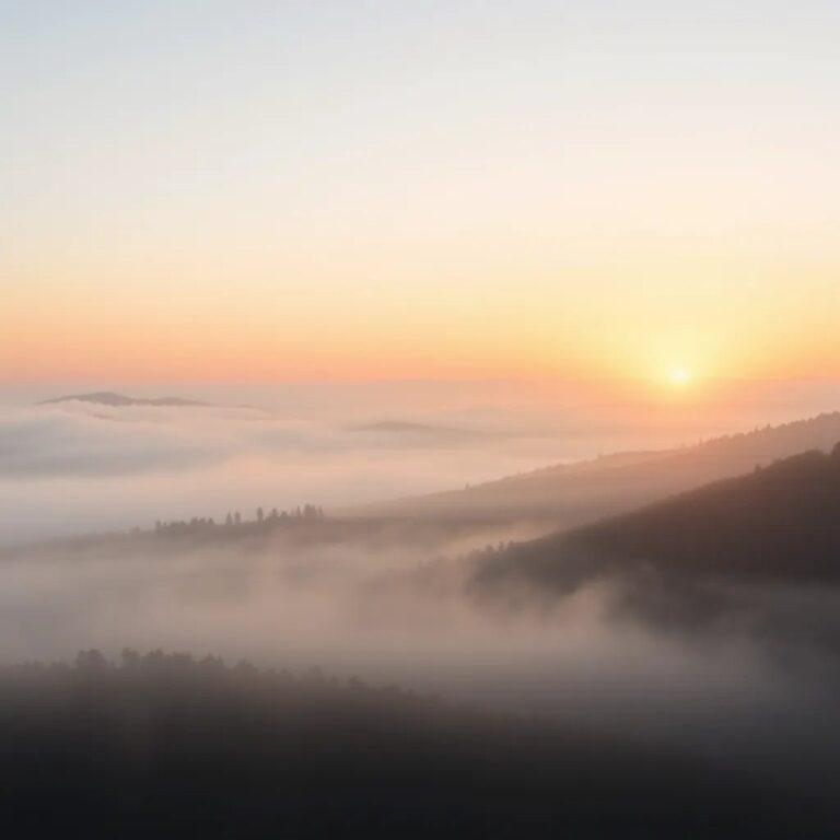 Un lever de soleil sur une vallée dans la brume